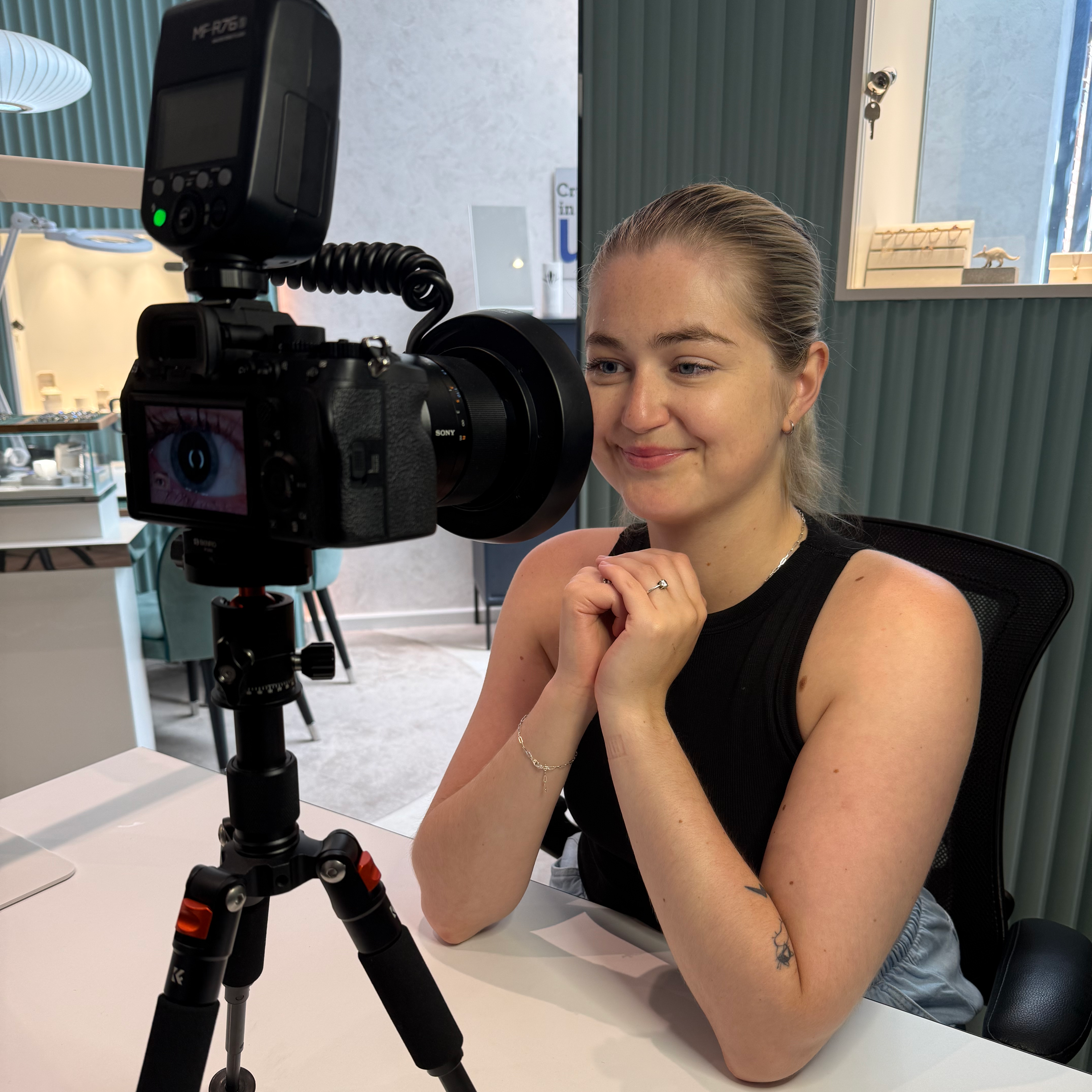 A client seated beside a macro camera in the bright Aardvark studio